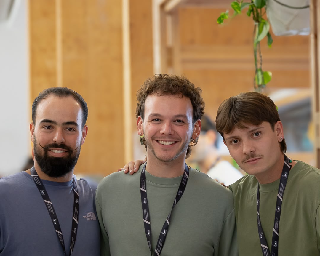 Les trois fondateurs d'Atelier Bercail, souriants, sur leur stand en bois